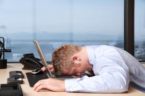 Picture of man with head on desk.