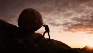 Picture of self-directed IRA real estate investment investor rolling rock up hill