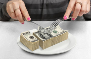 Picture for pass through entity tax cuts rules blog post shows a stack of dollar bills being cut up